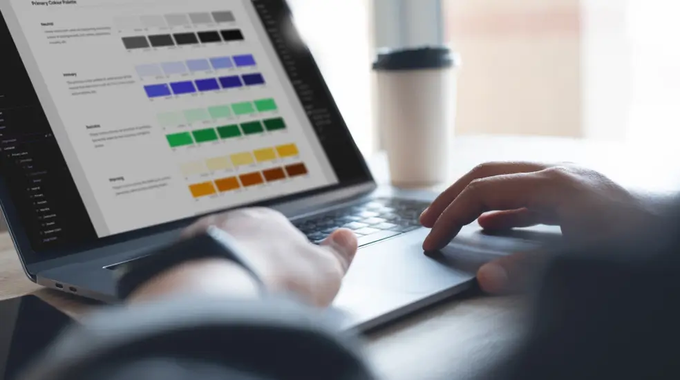 web designer using a laptop to create a sustainable design system